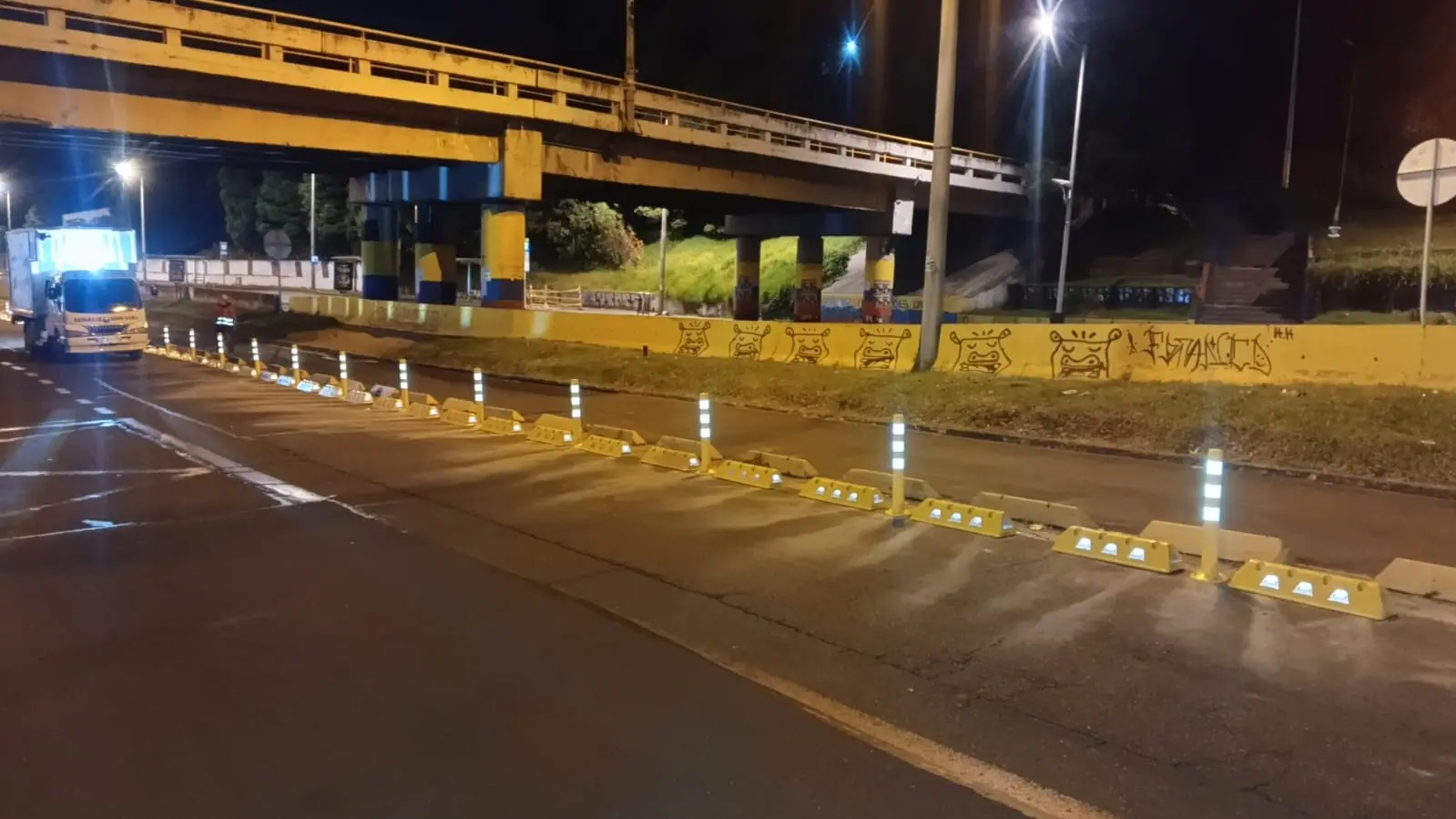 Separadores y delineadores reflectivos en una vía durante la noche
